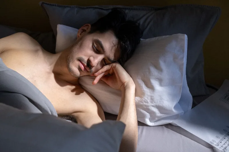 男性睡眠不足，躺在床上休息
